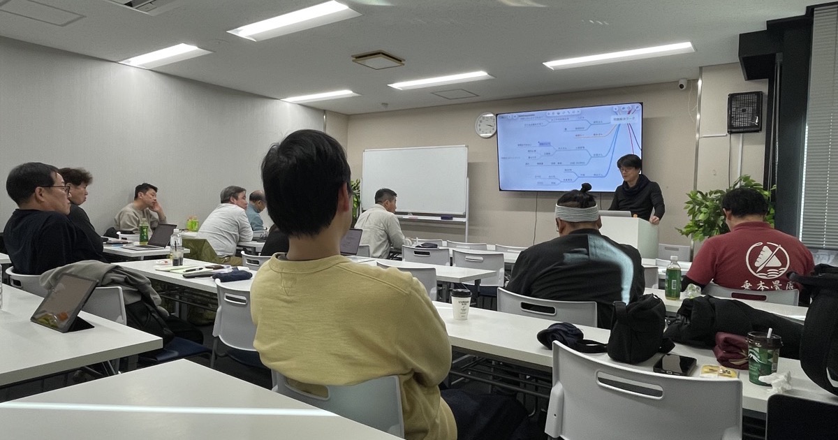 問題解決ワークの会場で、参加者が正面のスクリーンを見ている様子